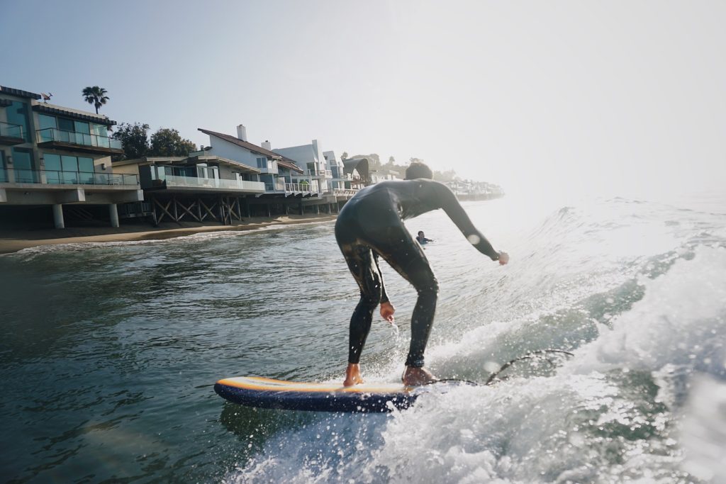 Surfing in front of Malibu Luxury Homes