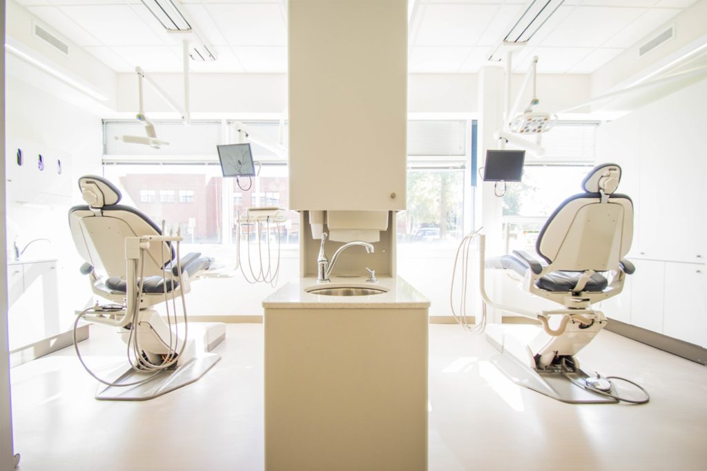 two white dentist chairs inside white painted room