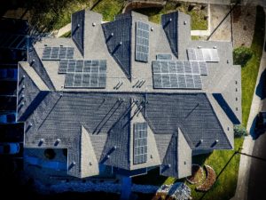 Bird's eye view from above of luxury home with solar panels
