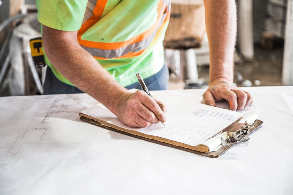 contractor writing on clipboard