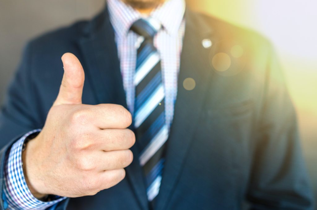 man in suit with thumbs up 