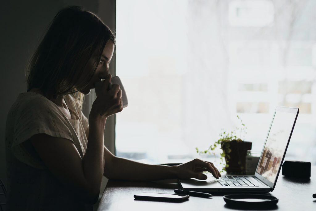 woman drinking coffee at home desk