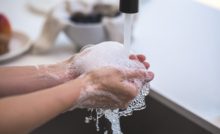 person washing their hands with soap