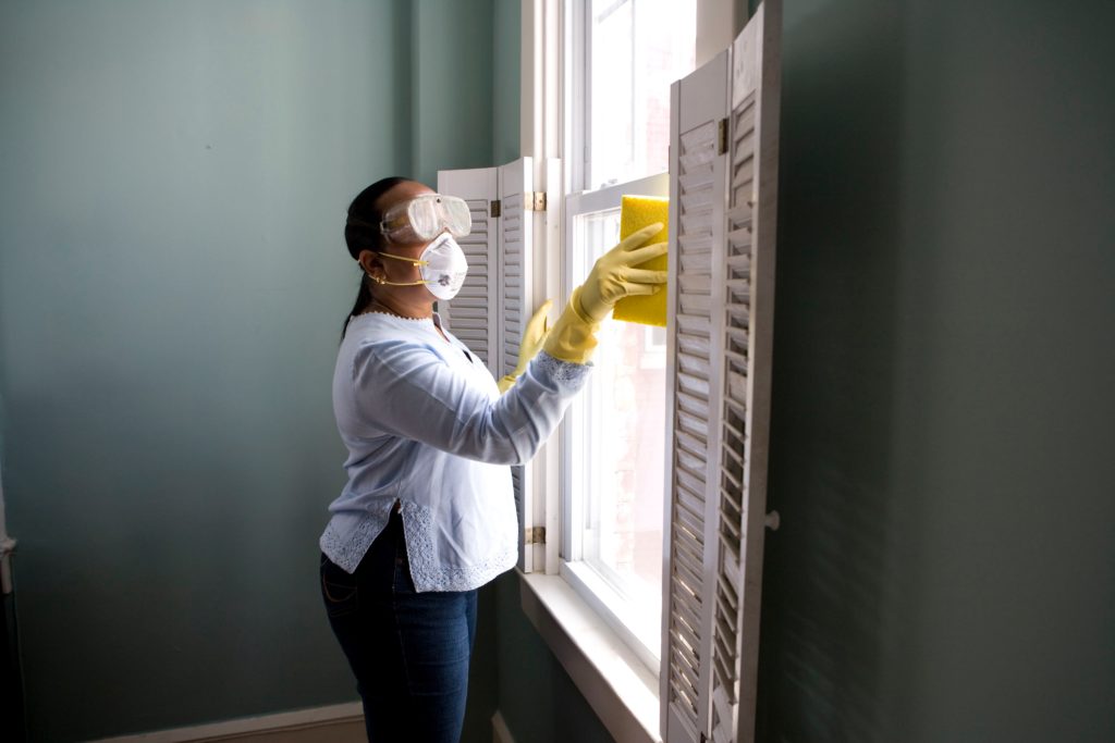 woman cleaning with face mask