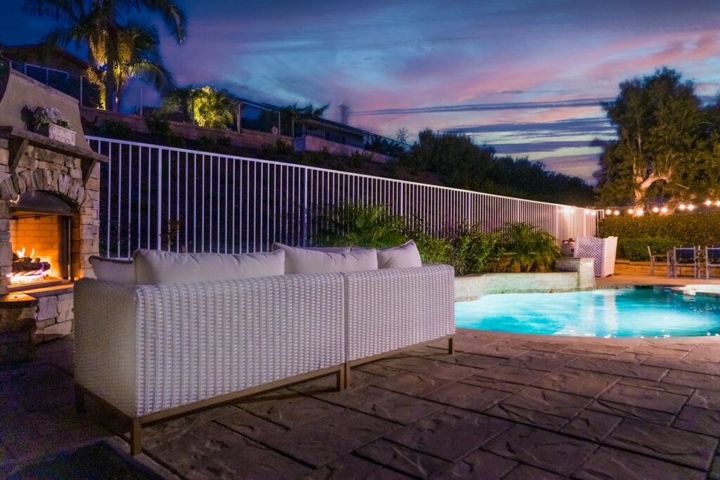 Southern California backyard with a pool, outdoor fireplace and lounge seating at dusk, the kind of outdoor living space that supports Calabasas home values