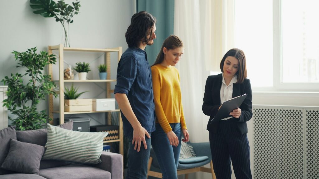 Real estate agent reviewing property details on a tablet with two home buyers during a Calabasas home showing